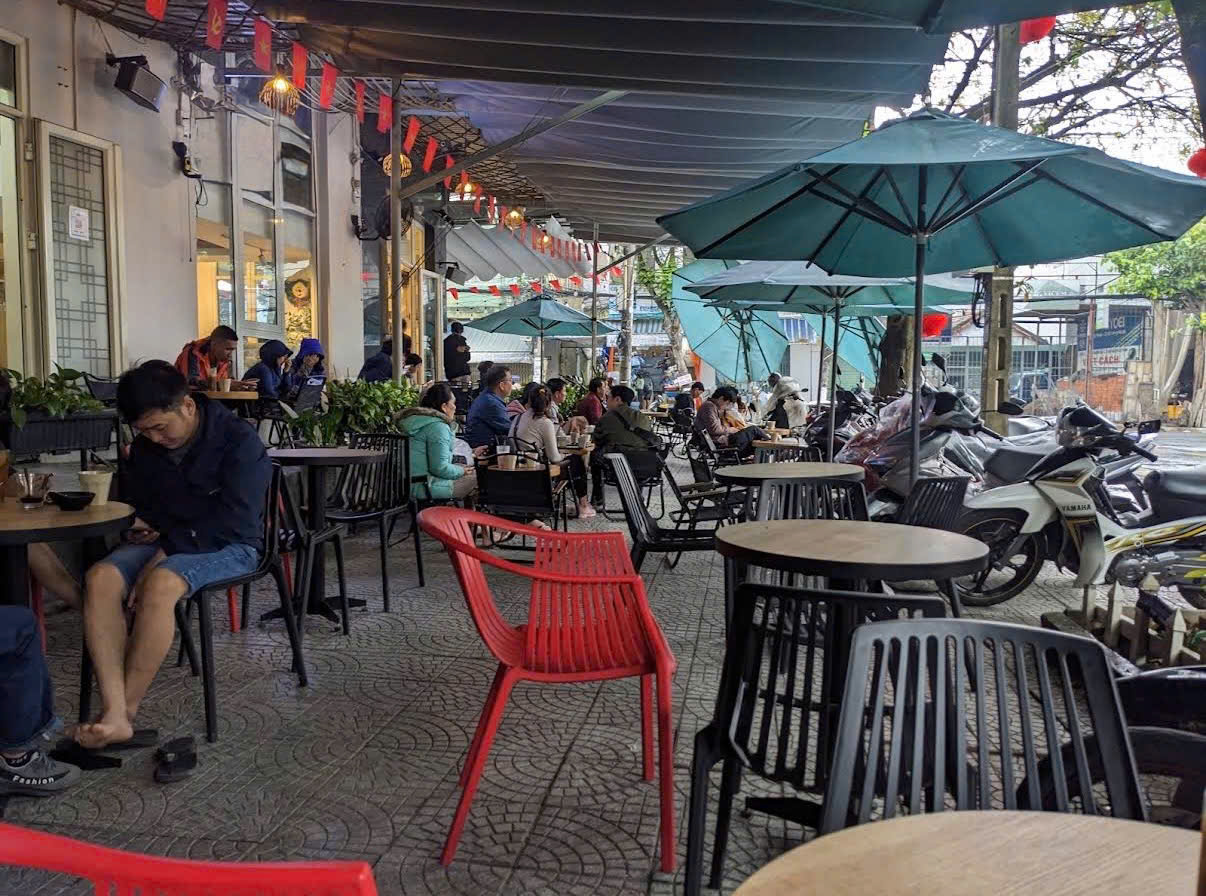 Sân cà phê phía trước, khách ngồi kín